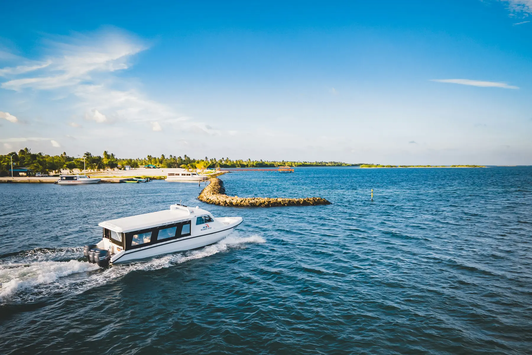 Speedboat crossing clear blue water in the Maldives